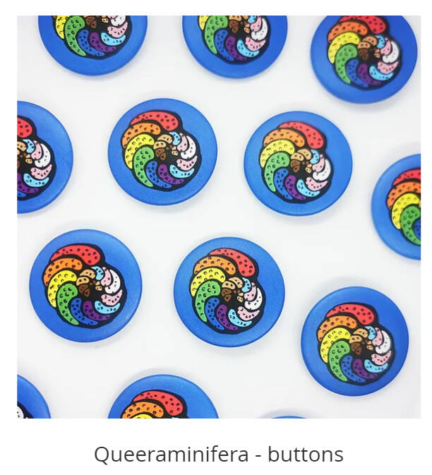 A photograph of numerous foraminifera button badges. Their chambers are colored in the colors of the Progres LGBTQ+ pride flag.
